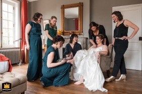 Wedding image: Bride in Clos st barthélemy, surrounded by six bridesmaids finishing her dressing. Candid shot of pre-ceremony preparations.